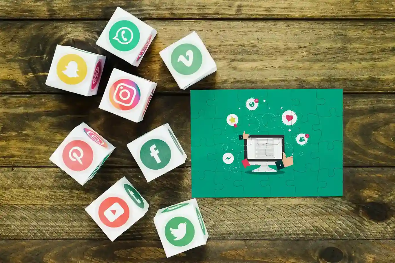Wooden blocks with social media icons connected to a central computer graphic, representing social-media-integration for business.
